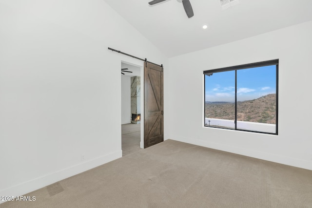 301 E Jomax Rd, Phoenix, AZ 85085 - empty room with a barn door, light colored carpet, a ceiling fan, baseboards, and vaulted ceiling