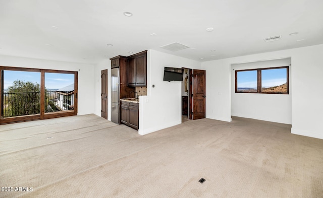 301 E Jomax Rd, Phoenix, AZ 85085 - unfurnished living room with light carpet, baseboards, a sink, and recessed lighting