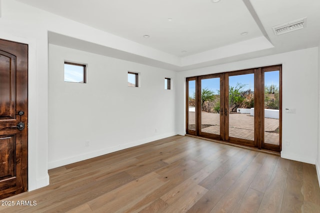 301 E Jomax Rd, Phoenix, AZ 85085 - unfurnished room featuring a tray ceiling, plenty of natural light, light wood-style floors, and baseboards