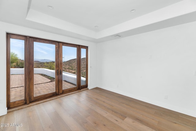 301 E Jomax Rd, Phoenix, AZ 85085 - spare room with a tray ceiling, a mountain view, french doors, baseboards, and hardwood / wood-style floors