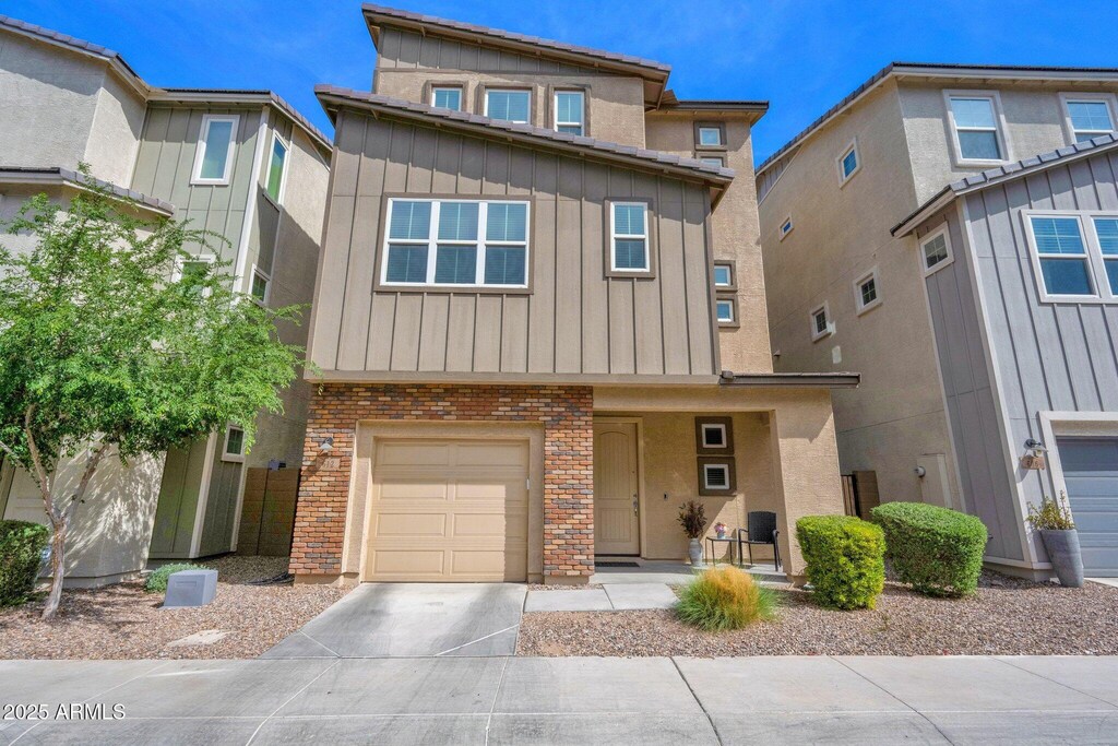 612 W Flintlock Way, Chandler, AZ 85286 - townhome / multi-family property with board and batten siding, stucco siding, a garage, and concrete driveway