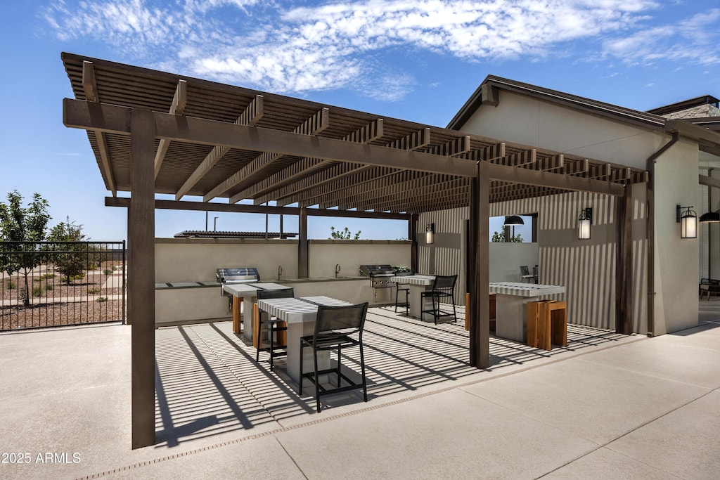 view of patio / terrace with an outdoor kitchen, a pergola, and a grill