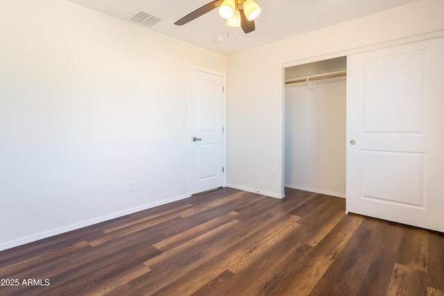 unfurnished bedroom with ceiling fan, dark hardwood / wood-style floors, and a closet