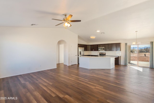 unfurnished living room with ceiling fan with notable chandelier, sink, dark hardwood / wood-style flooring, and vaulted ceiling