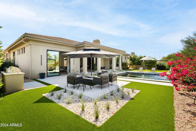 rear view of property featuring a fenced in pool, stucco siding, a patio area, and an outdoor hangout area