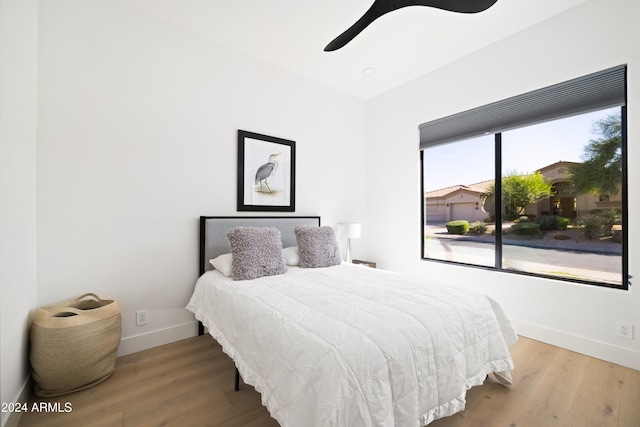 bedroom with wood finished floors, a ceiling fan, and baseboards