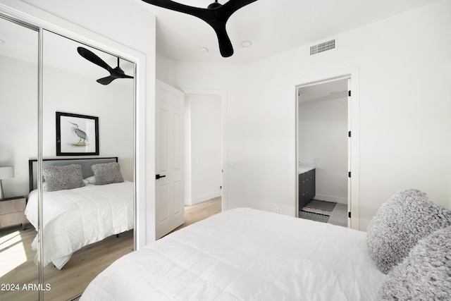 bedroom with connected bathroom, ceiling fan, a closet, and hardwood / wood-style flooring