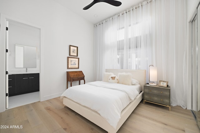 bedroom with a ceiling fan, light wood-type flooring, baseboards, and ensuite bathroom