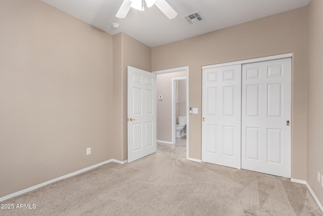 unfurnished bedroom featuring light carpet, a closet, and ceiling fan