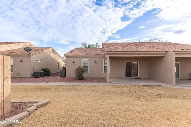 back of property with a lawn, cooling unit, and a patio area