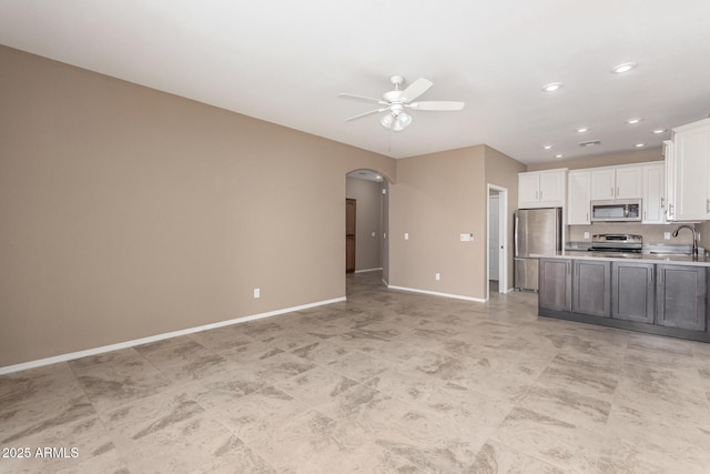 kitchen featuring sink, ceiling fan, white cabinets, and appliances with stainless steel finishes