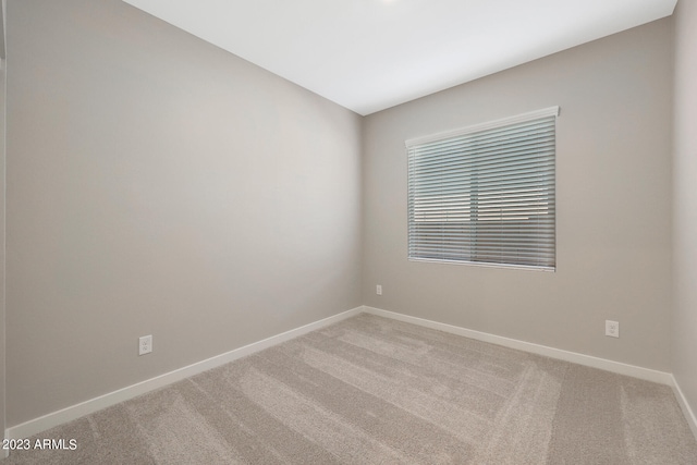 carpeted spare room featuring baseboards