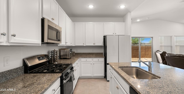 3020 W Bent Tree Dr, Phoenix, AZ 85083 - kitchen featuring appliances with stainless steel finishes, white cabinets, vaulted ceiling, dark stone countertops, and light tile patterned flooring