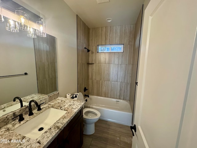 full bathroom with vanity, wood-type flooring, tiled shower / bath combo, and toilet