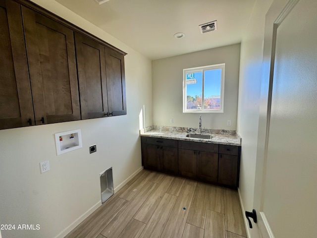 laundry room featuring cabinets, hookup for a washing machine, hookup for an electric dryer, sink, and light hardwood / wood-style floors