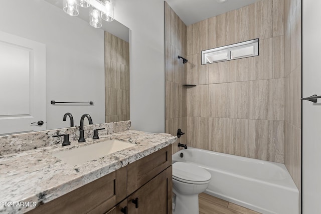 full bathroom featuring hardwood / wood-style floors, vanity, toilet, and tiled shower / bath