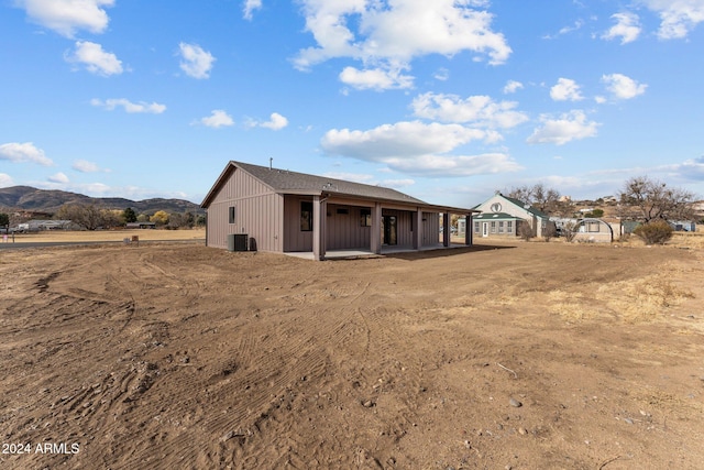 back of house featuring central AC and a mountain view