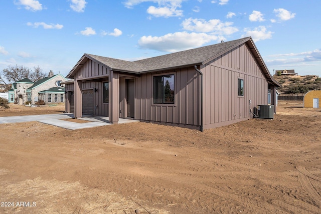 view of front of home featuring central AC unit and a garage