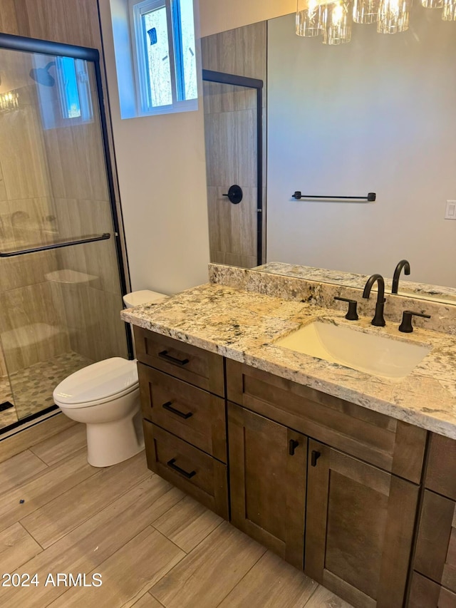 bathroom featuring vanity, toilet, and a shower with shower door