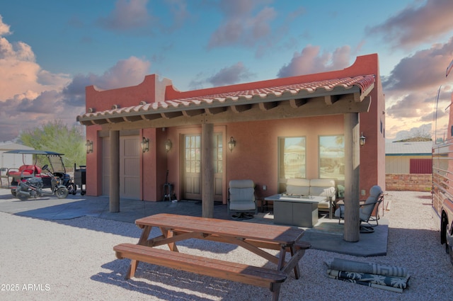 back of house with a patio, a tiled roof, and stucco siding