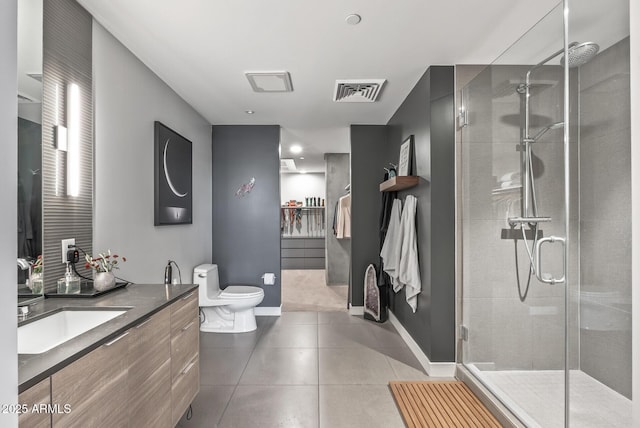 bathroom featuring walk in shower, vanity, toilet, and tile patterned flooring