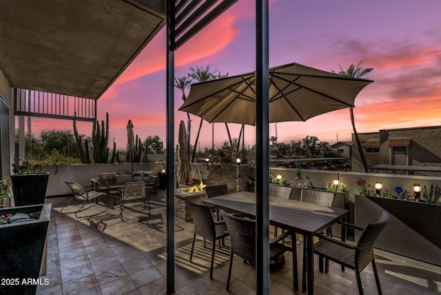 patio terrace at dusk with an outdoor living space with a fire pit