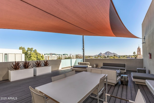 wooden terrace with an outdoor living space, a water and mountain view, and a grill