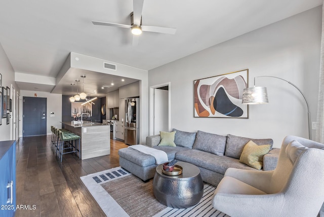 living room featuring dark hardwood / wood-style floors, sink, and ceiling fan