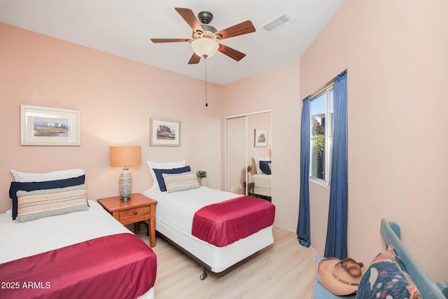 bedroom with ceiling fan, a closet, visible vents, and light wood-style floors