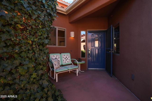 property entrance with a patio and stucco siding