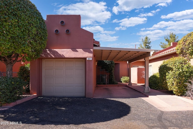 southwest-style home with a garage and stucco siding