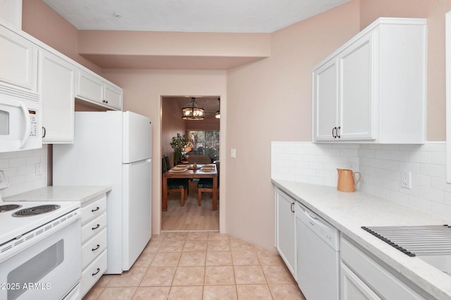 kitchen featuring white appliances, white cabinets, an inviting chandelier, and light tile patterned flooring