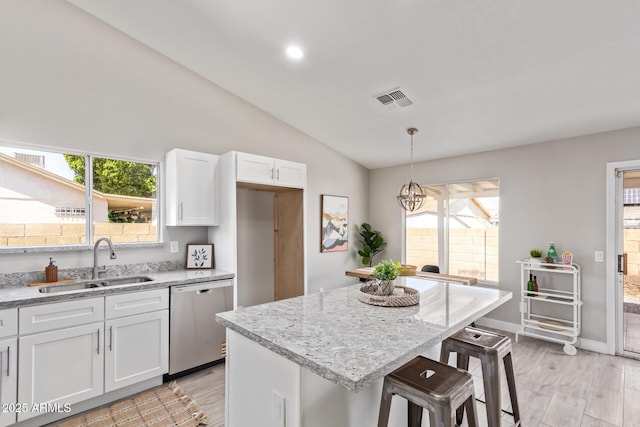 1408 E Carson Rd, Phoenix, AZ 85042 - kitchen with visible vents, stainless steel dishwasher, vaulted ceiling, a sink, and white cabinetry