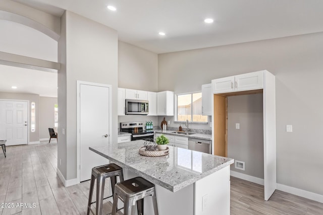 1408 E Carson Rd, Phoenix, AZ 85042 - kitchen featuring light stone countertops, baseboards, white cabinetry, a sink, and stainless steel appliances