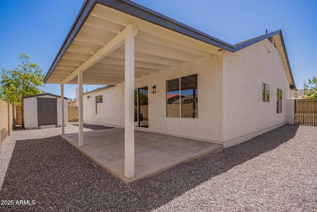 1408 E Carson Rd, Phoenix, AZ 85042 - back of property with a patio area, an outdoor structure, a fenced backyard, a shed, and stucco siding