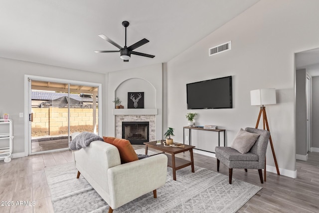 1408 E Carson Rd, Phoenix, AZ 85042 - living room with visible vents, a fireplace, baseboards, ceiling fan, and light wood-style flooring