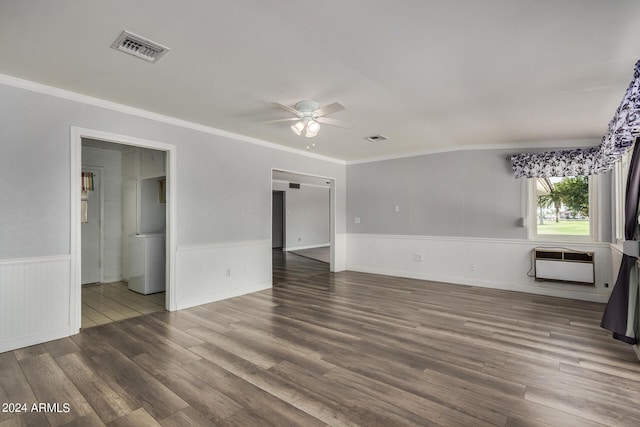 spare room with a wall mounted air conditioner, wood-type flooring, ornamental molding, and ceiling fan