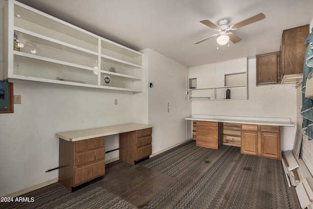 office with dark carpet, built in desk, and ceiling fan