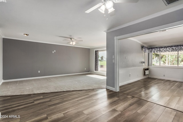 unfurnished room featuring a healthy amount of sunlight, ornamental molding, hardwood / wood-style floors, and heating unit