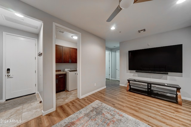 living room featuring washer / clothes dryer, light hardwood / wood-style flooring, and ceiling fan