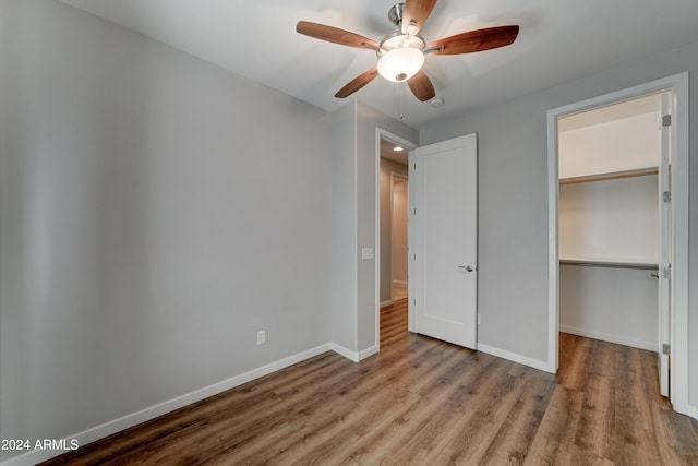 unfurnished bedroom with ceiling fan, wood-type flooring, and a closet