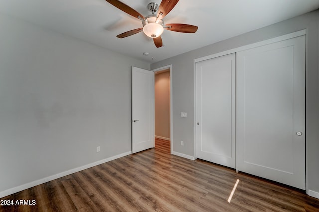 unfurnished bedroom with a closet, hardwood / wood-style flooring, and ceiling fan