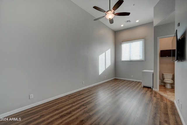 unfurnished bedroom with ceiling fan, lofted ceiling, dark wood-type flooring, and ensuite bath