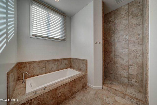 bathroom featuring a relaxing tiled tub