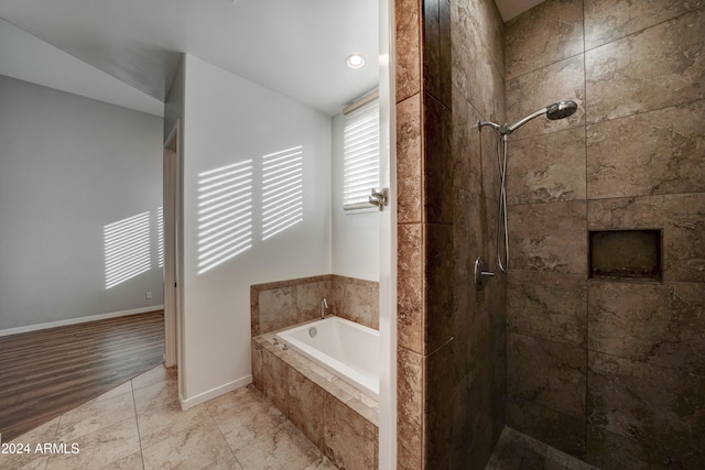 bathroom featuring hardwood / wood-style floors, separate shower and tub, and vaulted ceiling