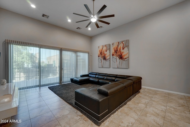 living room featuring a wealth of natural light, a towering ceiling, and ceiling fan