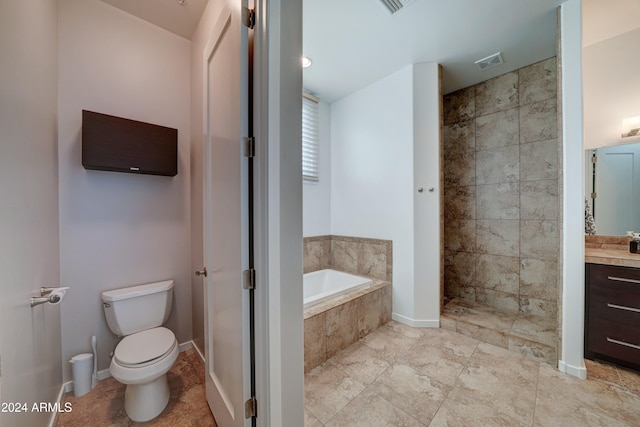 bathroom featuring tiled tub, vanity, and toilet