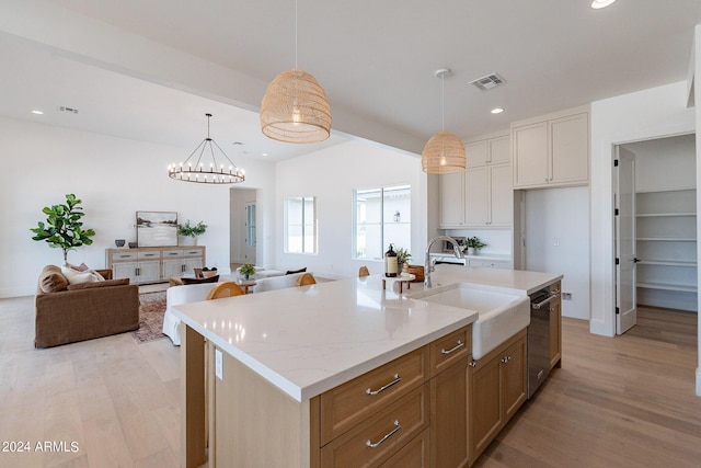 kitchen featuring white cabinetry, stainless steel dishwasher, sink, and a center island with sink