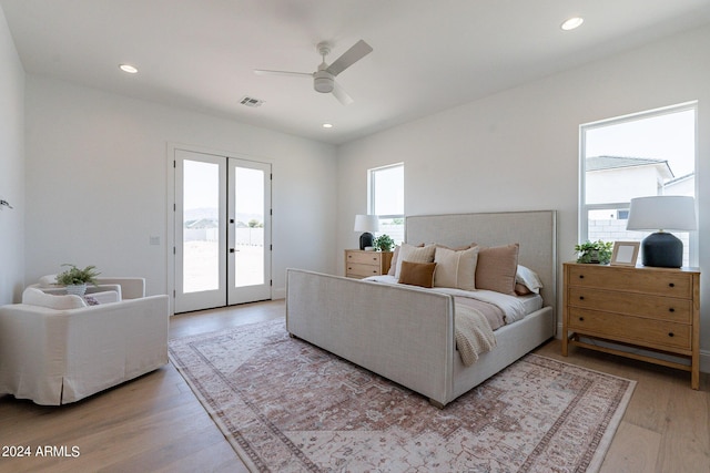 bedroom with light wood-type flooring, access to exterior, ceiling fan, and french doors