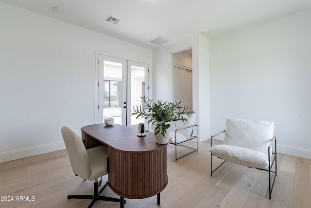 home office featuring light hardwood / wood-style floors and french doors